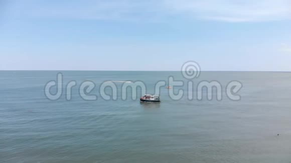 船在海上航行人们在海滩上晒日光浴鸟瞰海滩和大海大海上的波浪海洋海滩视频的预览图