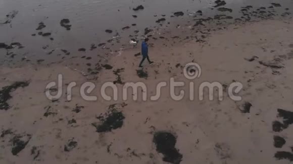 一个孤独的人走在海滩上从上面俯瞰视频的预览图