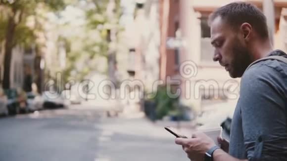 自信成功的白种人商人站在城市街角用移动办公智能手机应用程序喝咖啡视频的预览图