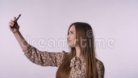 年轻的快乐女人在智能手机上自拍交流理念白色背景视频的预览图
