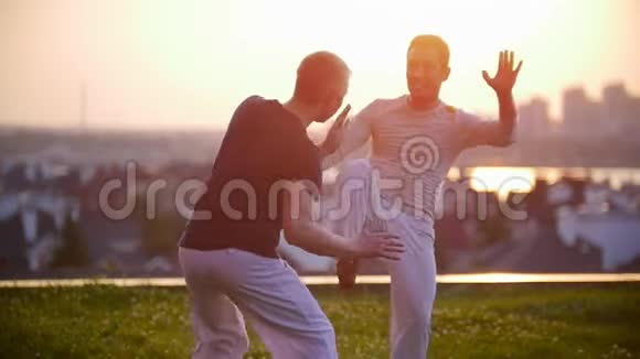 强壮的运动员们训练着在令人惊叹的夕阳下挥舞着双腿和双手在草地上视频的预览图