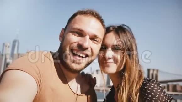 微笑快乐的白种人年轻夫妇站在史诗般的纽约天际线曼哈顿亲吻和自拍照片视频的预览图