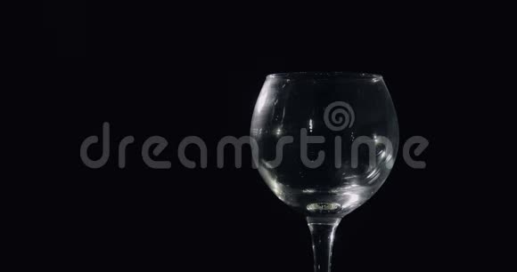 把粉红色的香槟从瓶子里倒入玻璃杯里黑色背景视频的预览图