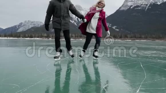 一对夫妇一起在冰冻的湖面上滑冰视频的预览图