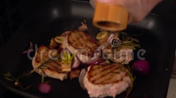 厨师在烤猪肉奖章上磨辣椒视频的预览图