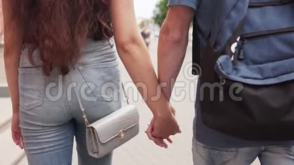 年轻人和女人牵着手一起走在城市大街上视频的预览图