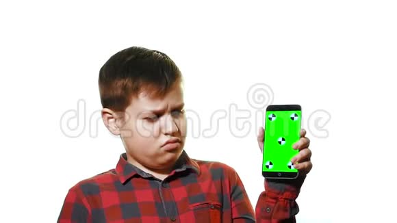 悲伤的男孩手里拿着一部智能手机手里拿着一个绿色的屏幕视频的预览图