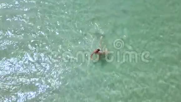 顶景女子在绿松石海水中游泳在天堂沙滩上享受清澈大海沐浴的女人视频的预览图