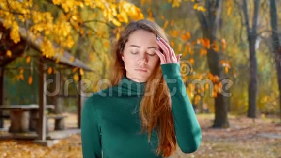 秋天一个年轻漂亮的黑发女人正在公园里散步公园的背景是黄树视频的预览图