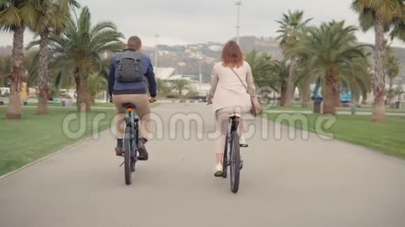男人和女人在夏天阴天的时候在城市公园骑自行车视频的预览图