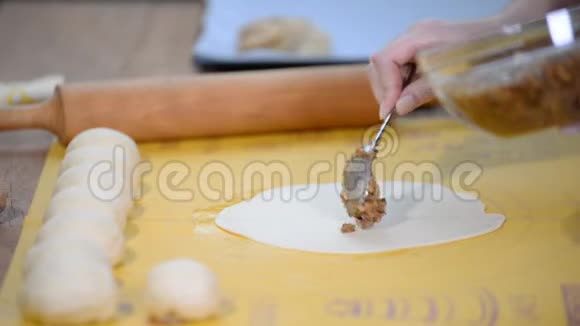 厨师把坚果馅放在面团上做酵母甜面包视频的预览图