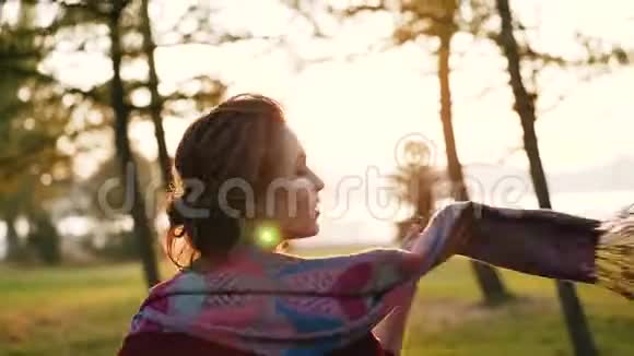 快乐的女孩在一个阳光明媚的秋天在一个令人惊叹的公园里带着围巾玩耍和旋转视频的预览图