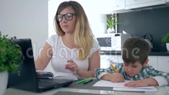 为人父母多任务妈妈在家里和儿子一起在厨房工作视频的预览图