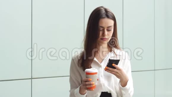 使用智能手机提供热饮的成年女商人视频的预览图