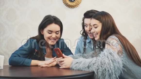 快乐的不同的朋友一起使用电话在咖啡馆午餐看着智能手机屏幕大笑的男人视频的预览图