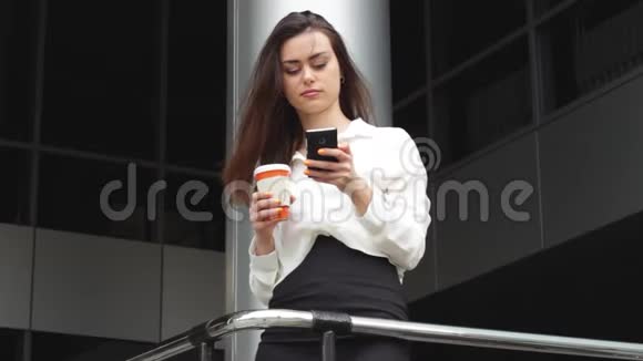 女商人用智能手机热饮办公室在后面视频的预览图