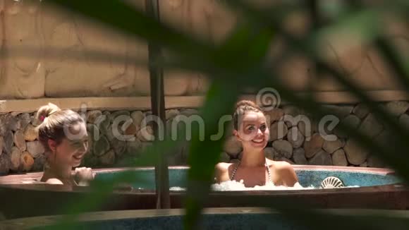 在豪华水疗中心享受按摩浴缸的幸福女人微笑的女人在按摩浴缸中放松和享受沐浴视频的预览图