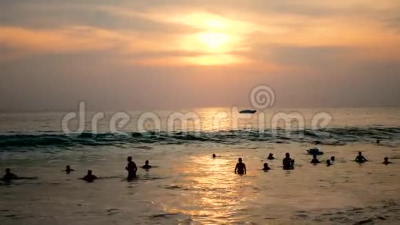 日落时分许多人在海上巨浪上摇摆视频的预览图