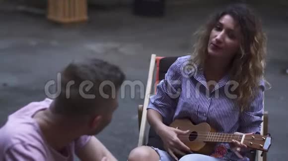 年轻女孩为她的伴侣演奏四弦琴视频的预览图