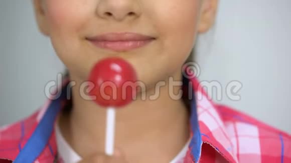 小女孩喜欢Lollypop快乐的童年概念牙齿健康特写视频的预览图