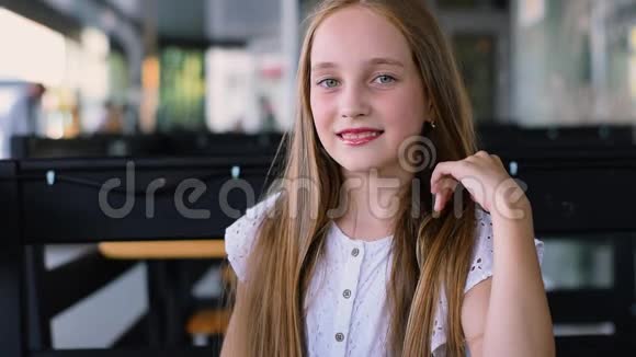 迷人的年轻女孩展望相机和微笑的肖像近距离射击视频的预览图