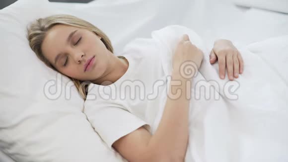 年轻漂亮的女性安静地睡在舒适的骨科床垫上视频的预览图