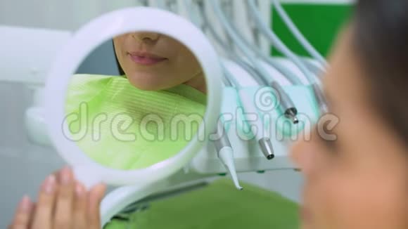 美丽的微笑映在镜子里女人对牙齿的治疗很满意视频的预览图