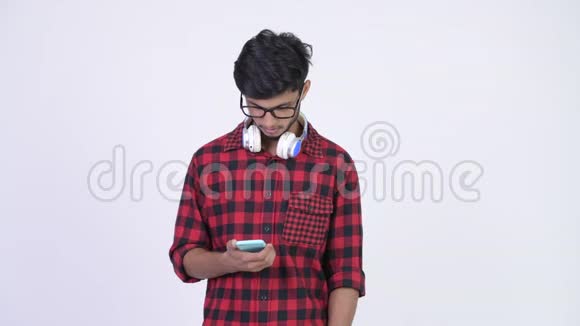 年轻英俊的留胡子的印度时髦男人用电话看上去很惊讶视频的预览图