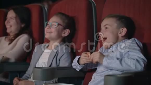 孩子们在电影院里热情地看电影儿童娱乐概念视频的预览图