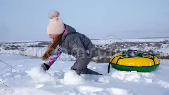 一个小女孩站在管子旁边和一个带雪的人玩视频的预览图