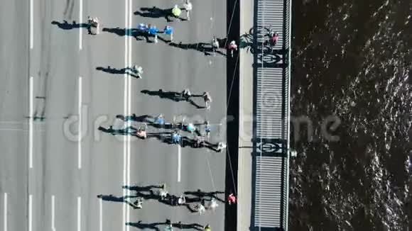 运动员们沿着巨大的灰色桥梁跑夏季马拉松视频的预览图