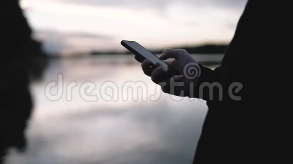 男人使用智能手机户外日落背景视频的预览图