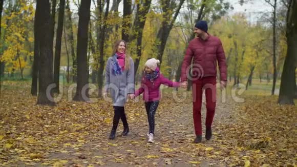 与女孩在秋天公园散步的欢乐家庭视频的预览图