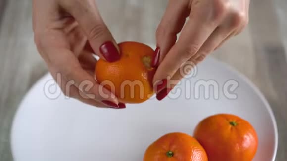 女人手剥橘子皮橘子片堆在盘子里视频的预览图