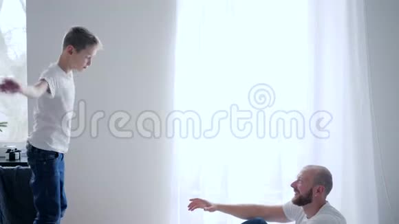 快乐的时刻一家人穿着同一件白色T恤衫在家里的床上玩得开心视频的预览图