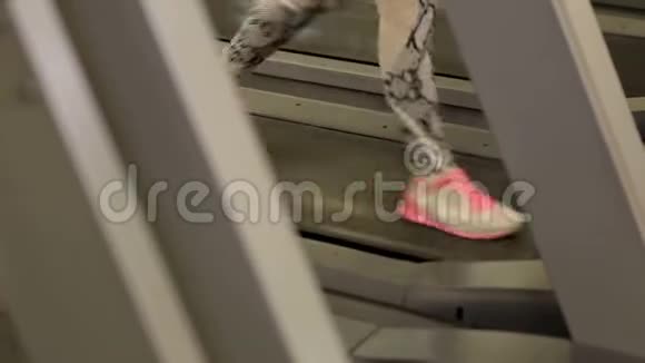 那个女孩在健身房的跑步机上跑步健身理念特写镜头视频的预览图
