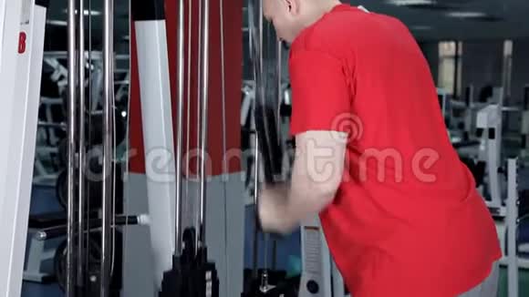 健身房里的一个男人抖他的三头肌视频的预览图