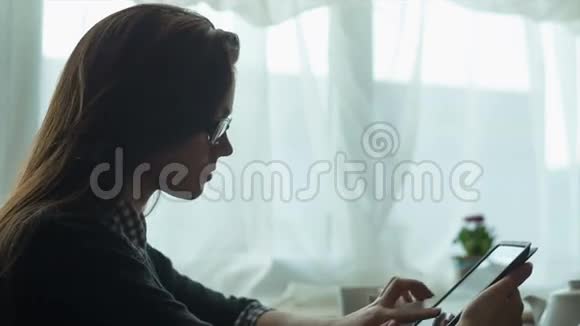 女商人在咖啡馆里用平板电脑和笔记本视频的预览图