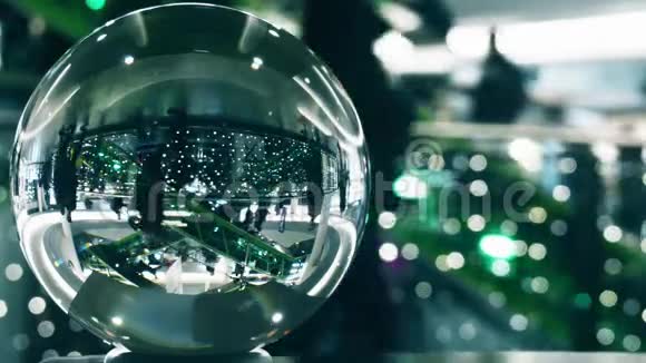 无法辨认的顾客在圣诞节和新年装饰的购物中心在玻璃球上扭曲的视野视频的预览图