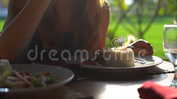 一位年轻女子在日落时分吃晚饭身后有一片稻田视频的预览图