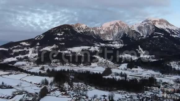 积雪覆盖的村庄和一座大山空中拍摄4k片视频的预览图