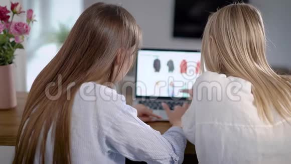 两个年轻的女性朋友正坐在家里在网上购物他们使用带wifi的现代笔记本电脑视频的预览图