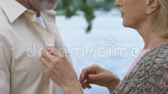 成熟的男人带着爱和温柔有爱心的女人扣上衬衫的扣子视频的预览图