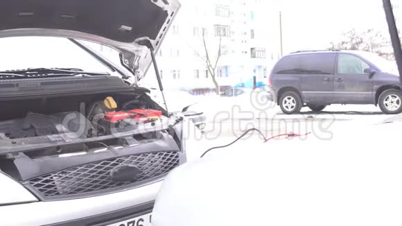 一个人把捐赠汽车的高压电线连接起来用放电电池给汽车发动机充电跳开视频的预览图