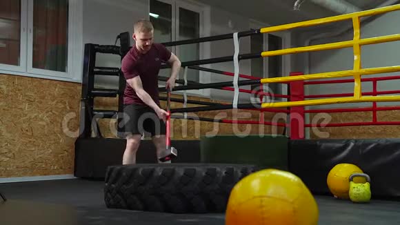 一个人在健身房里用大锤敲打轮胎视频的预览图