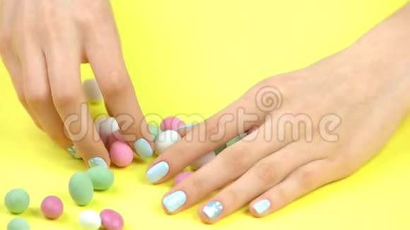 手和五颜六色的糖果慢动作视频的预览图