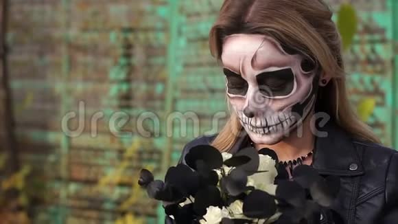 可怕的新娘与一束黑色的花和化妆形式的头骨视频的预览图