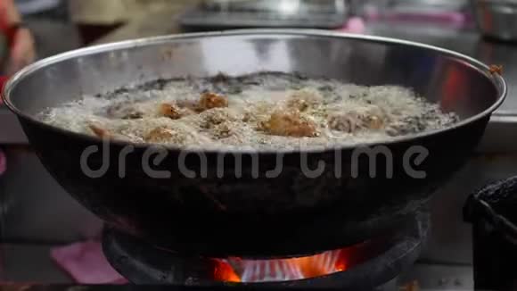 面包鸡在一个深油炸锅里烹饪里面装满了热的冒泡的植物油在当地的街头市场4k视频的预览图