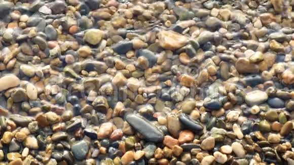 海边的卵石被水缓慢地冲洗特写视频的预览图