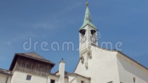 在白色的石头中世纪城堡上倾斜钟楼在蓝天背景下视频的预览图